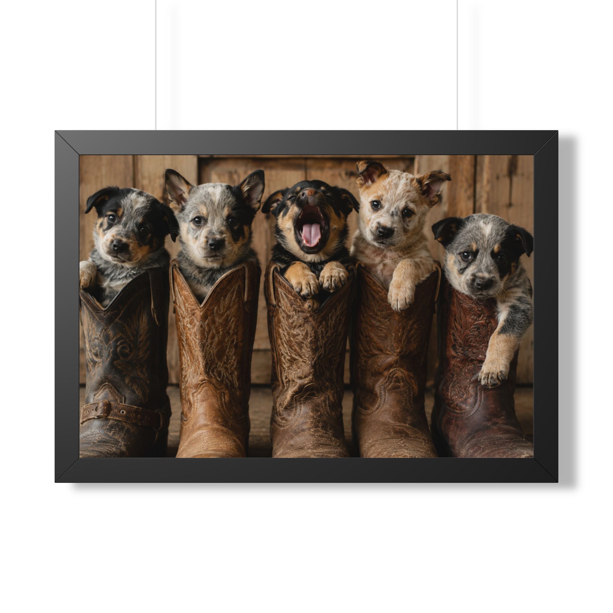 Black Frame - Adorable puppies peeking from weathered cowboy boots create a heartwarming blend of Western charm, playful personalities, and rustic farmhouse style.