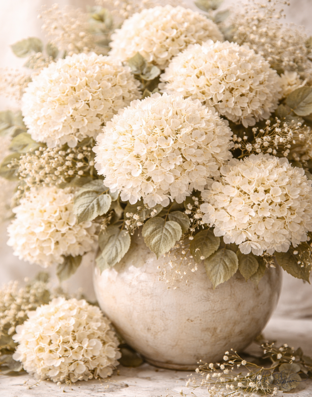 White hydrangea flowers in a textured vase on a wooden surface
